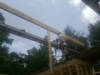 Carpenter setting a ridge beam over a new addition frame — Ice Dam Removal by Roofing Brothers in Meridian